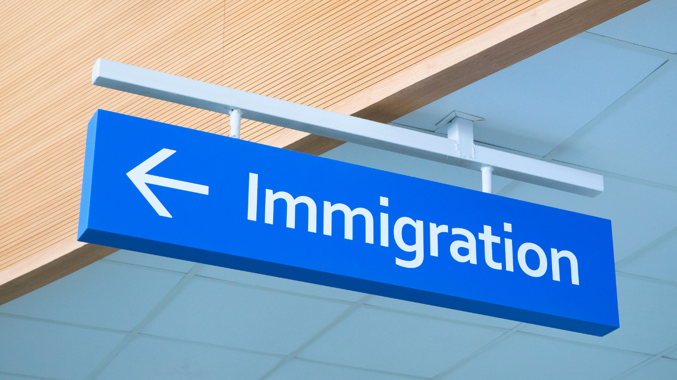 Blue immigration sign with an arrow in an airport or government building